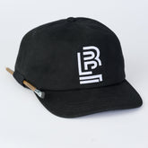 Black canvas cap with white Blackwing emblem embroidered on the front. Features a loop on the side to hold a pencil.