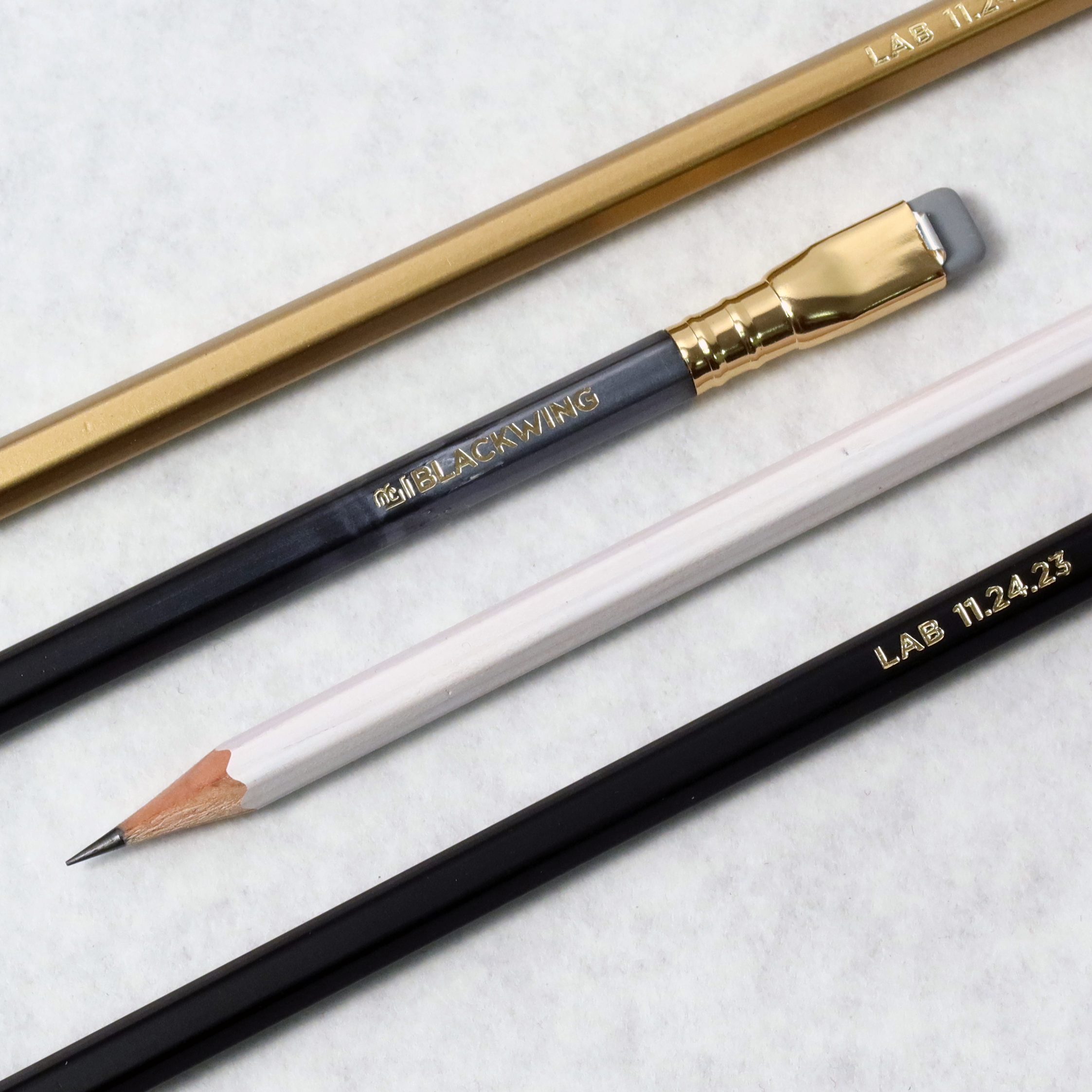 Three Blackwing Lab 11.24.23 pencils on a white surface.