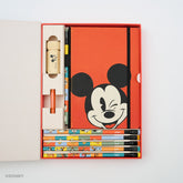 A Disney-themed stationery gift set displayed in an open red box on a white background. The set includes a blue notebook with a large Mickey Mouse face, several colorful pencils, a beige Mickey pencil sharpener, a red pencil point guard, and several colorblock pencils with Mickey Mouse, Minnie Mouse, Pluto, Goofy, Donald Duck, and Daisy Duck.