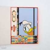 A Disney-themed stationery gift set displayed in an open red and white box on a white background. The set includes a blue notebook with a large Donald Duck face, several colorful pencils, a beige Mickey pencil sharpener, a red pencil point guard, and several colorblock pencils with Mickey Mouse, Minnie Mouse, Pluto, Goofy, Donald Duck, and Daisy Duck.