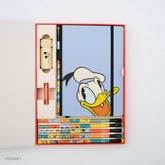 A Disney-themed stationery gift set displayed in an open red and white box on a white background. The set includes a blue notebook with a large Donald Duck face, several colorful pencils, a beige Mickey pencil sharpener, a red pencil point guard, and several colorblock pencils with Mickey Mouse, Minnie Mouse, Pluto, Goofy, Donald Duck, and Daisy Duck.
