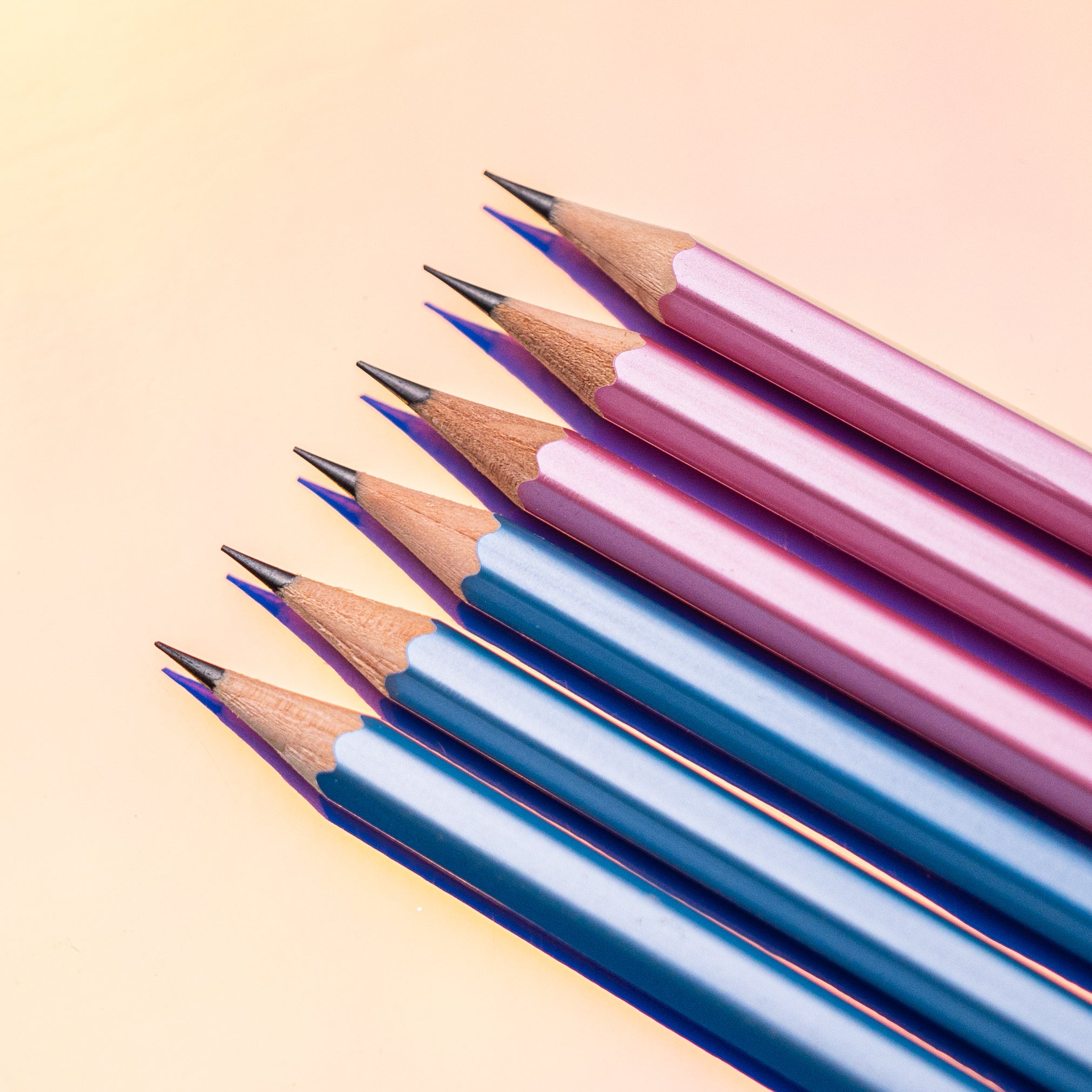 A row of Blackwing Pearl - Blue pencils on a pink background.
