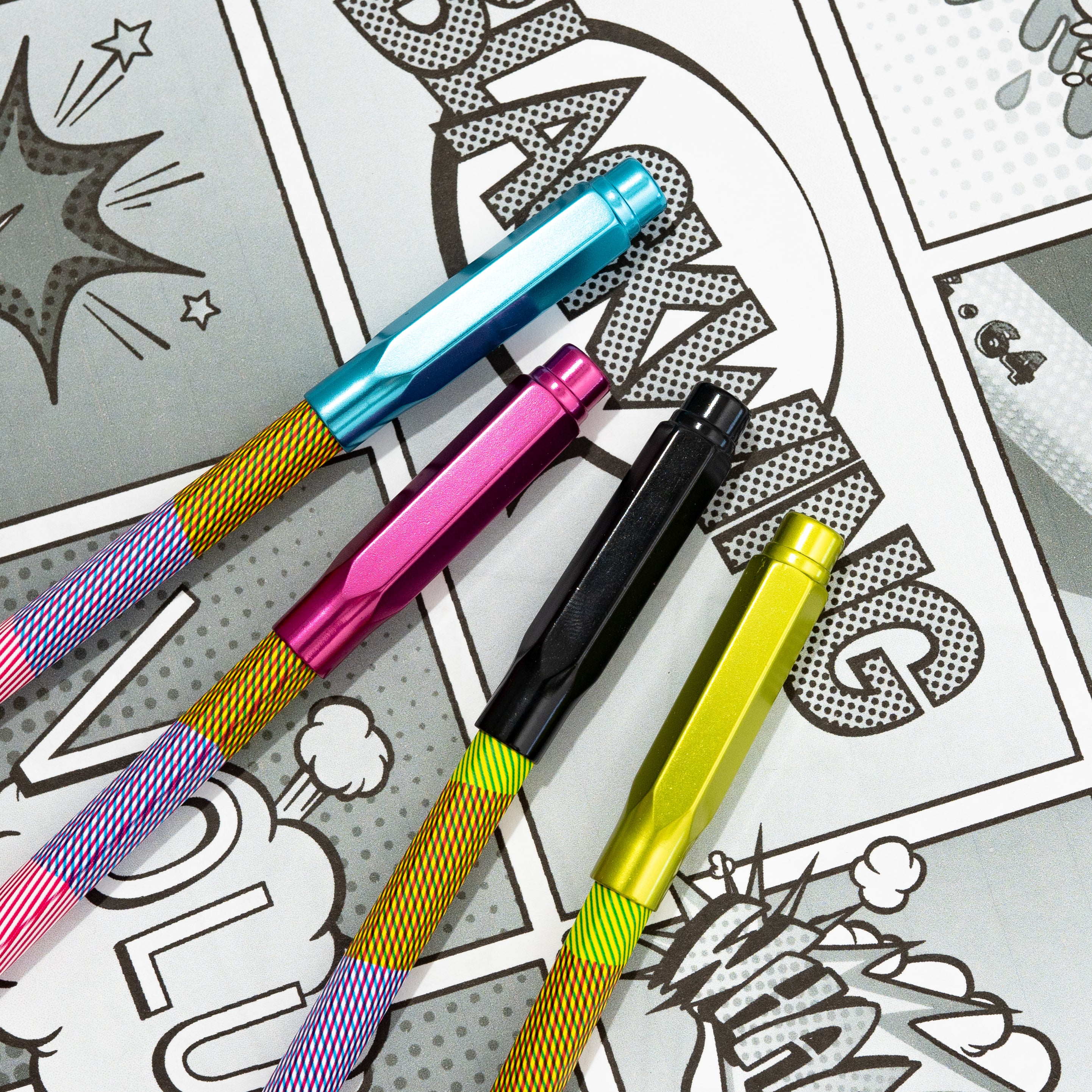 Three Blackwing Volume 64 Point Guards (Set of 4) lying on an open notebook with comic books graphics.