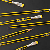 A group of yellow and Blackwing Volume 651 pencils on a dark surface.