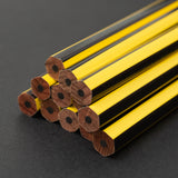A group of Blackwing Volume 651 pencils on a black surface.