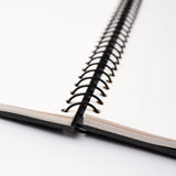 A Blackwing Spiral Notebook rests on a white surface.