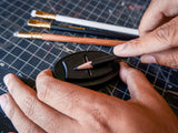 A person using a Blackwing Høvel to draw on a piece of paper.