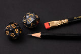 A Blackwing Volume 20 dice and a pencil laying on a black surface, perfect for tabletop games.