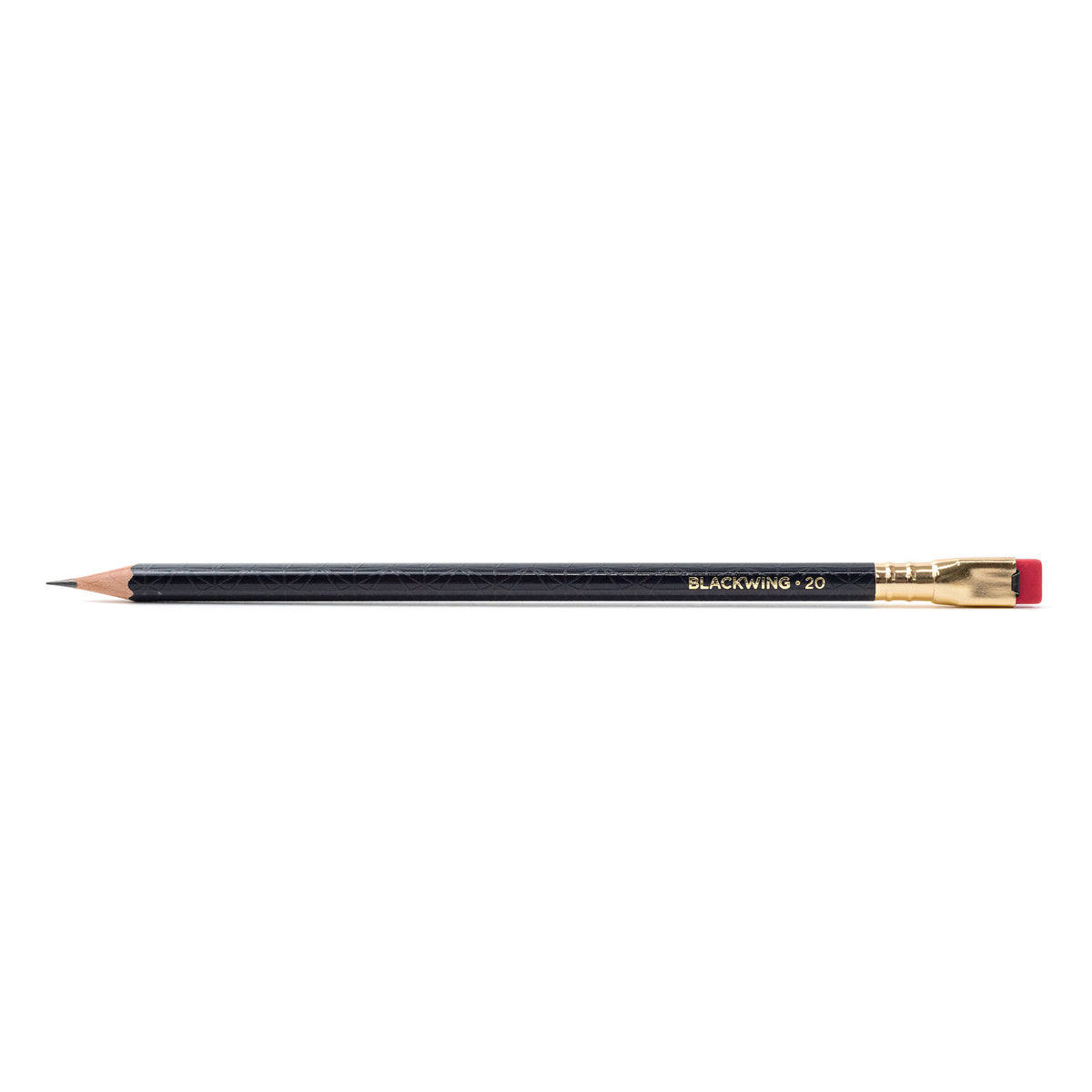 A Blackwing Volume 20 (Set of 12) pencil with a red tip rests on a white tabletop.