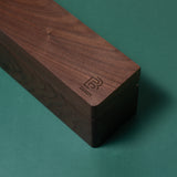 A Blackwing Walnut Box with a logo on it, perfect for storing Blackwing pencils.