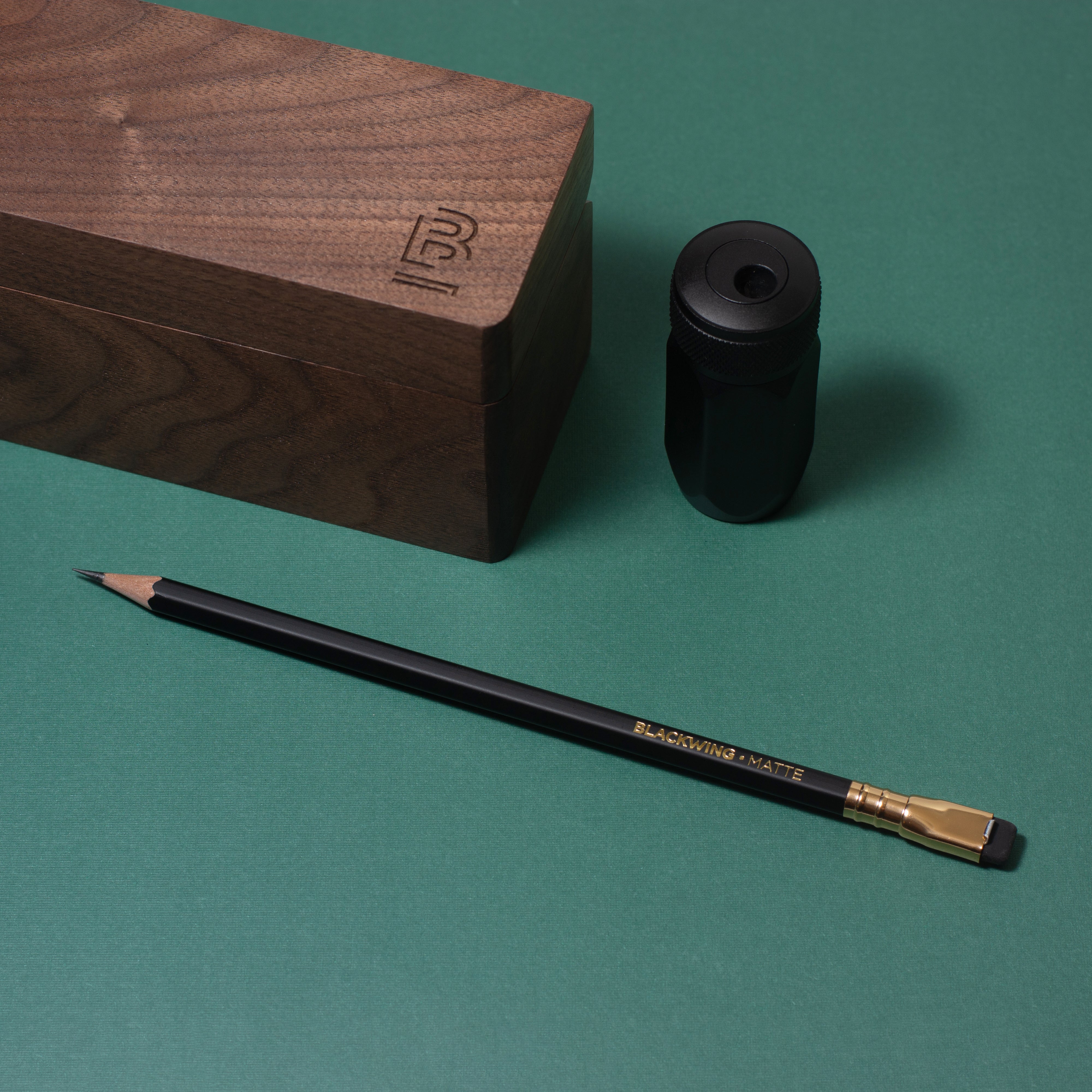 A pencil next to a Blackwing Walnut Box.