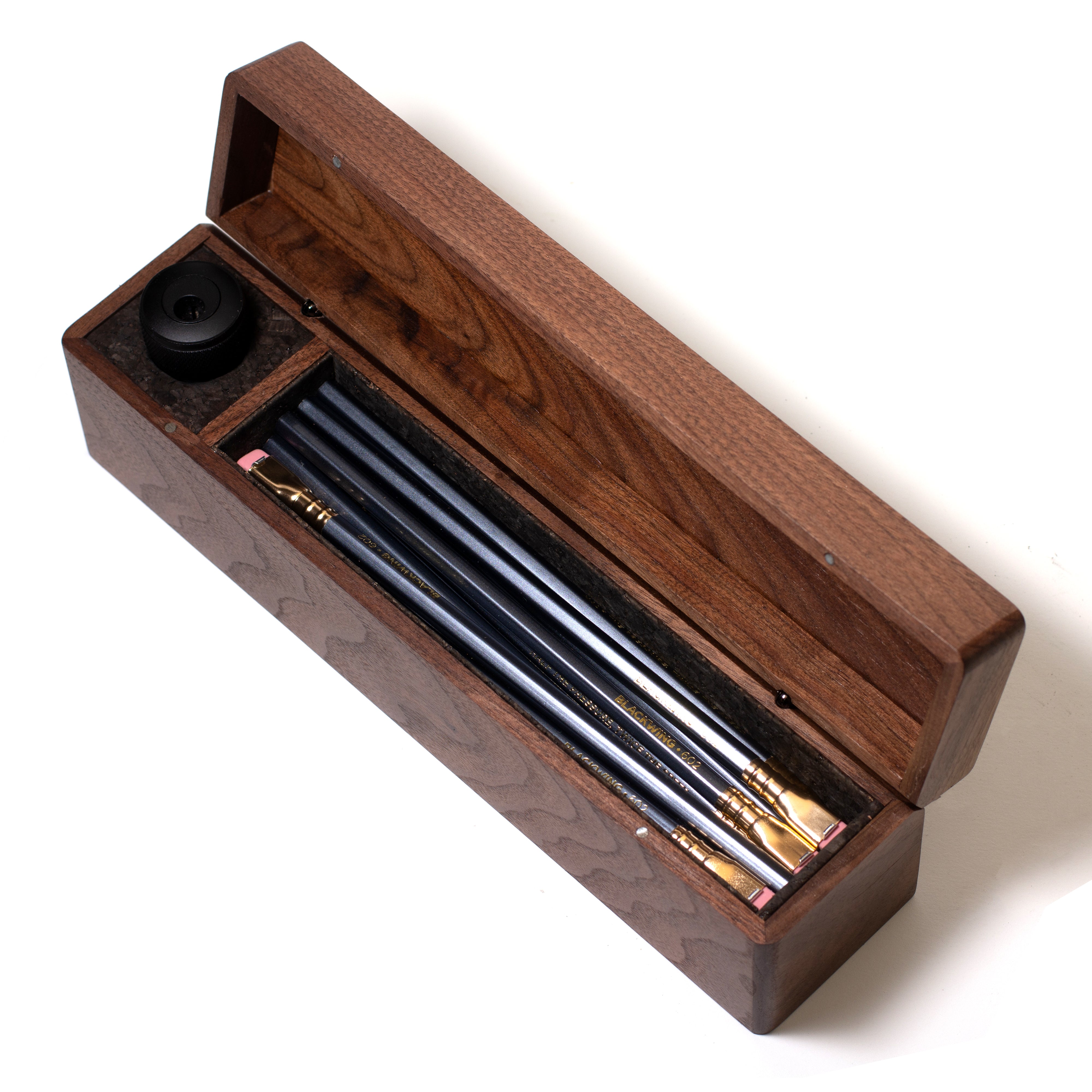 A Blackwing Walnut Box filled with Blackwing pencils.