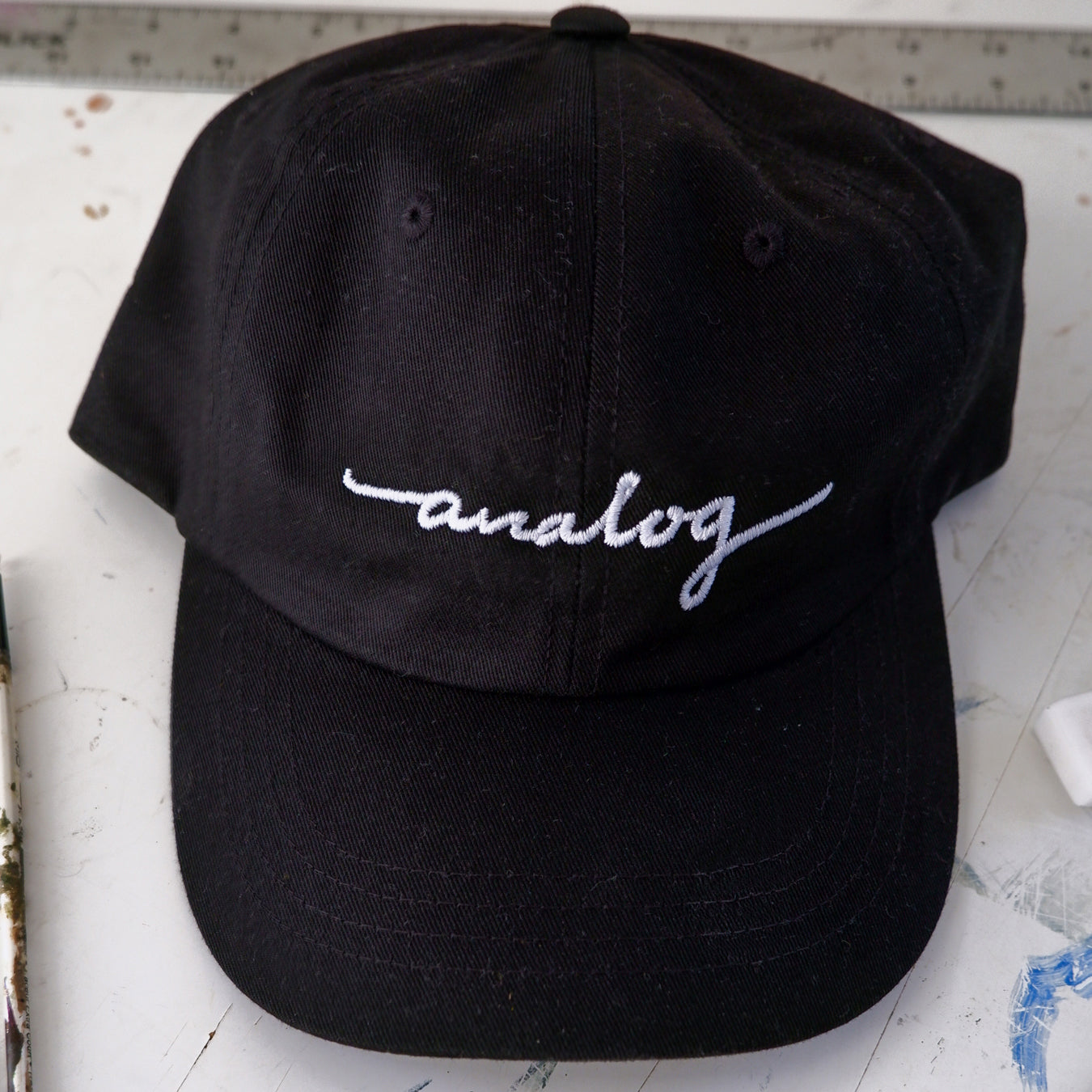 A black Analog hat with the word 'anda' inscribed on it.
