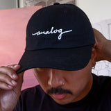 A man wearing a black Analog Hat with the word "Blackwing" on it.