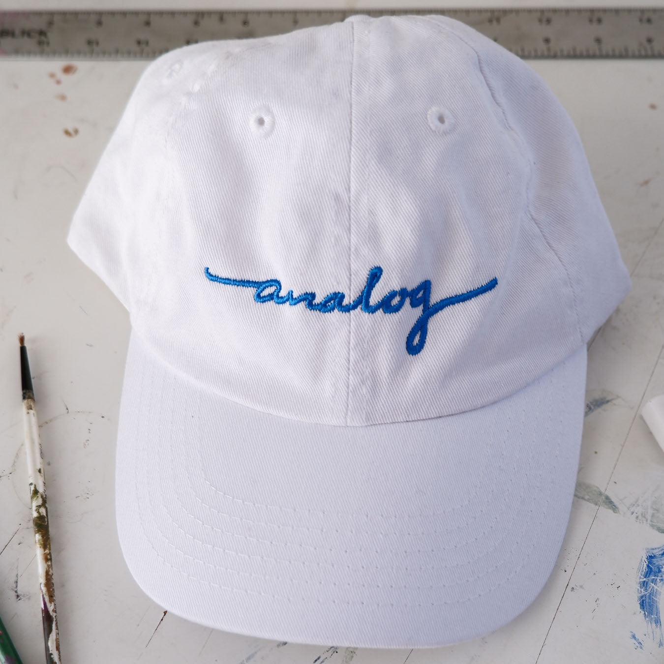 An Analog Hat with blue writing on it.