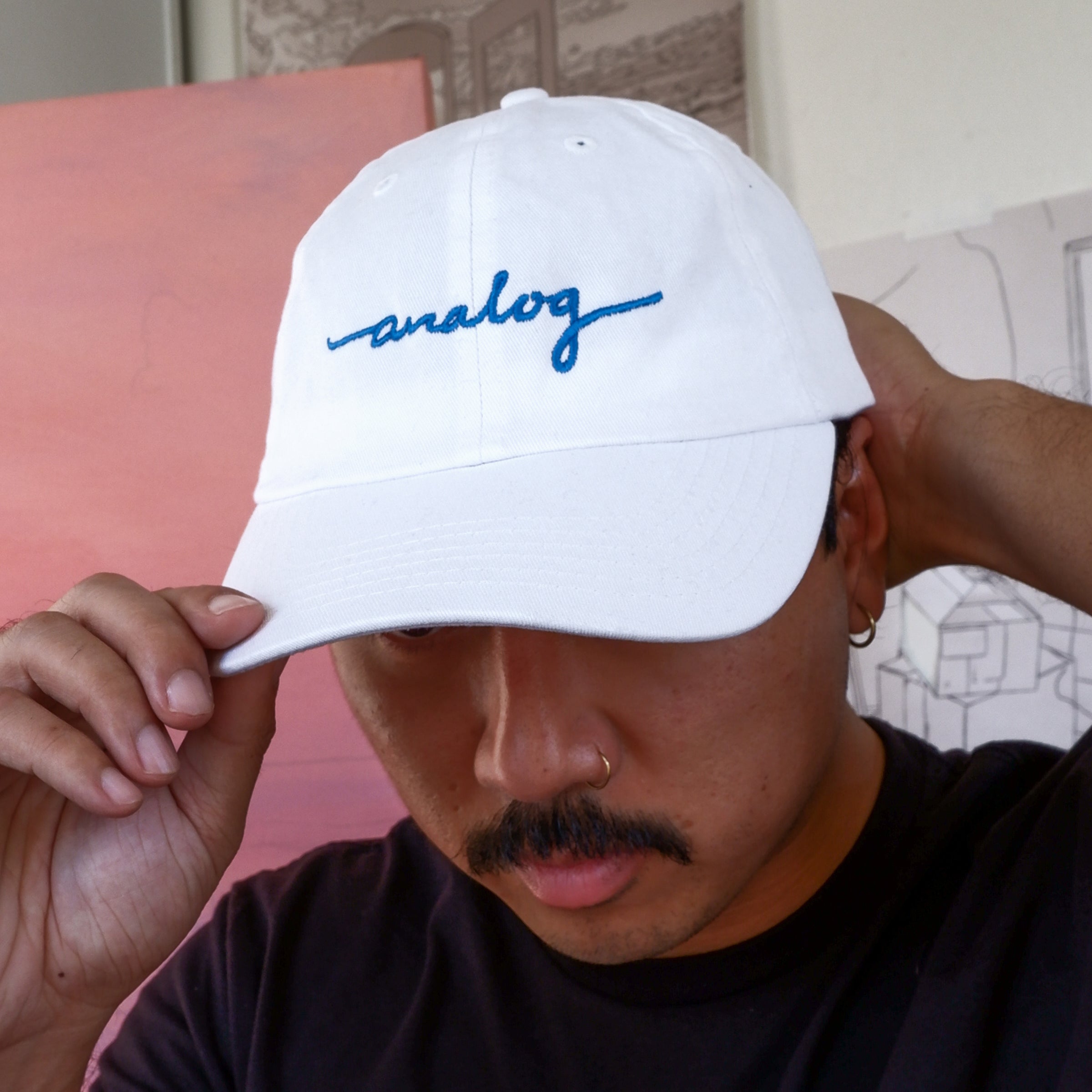 A man wearing an Analog Hat with Blue lettering.