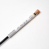 A Blackwing Gift Card Pencil with a black tip sits on a white surface.