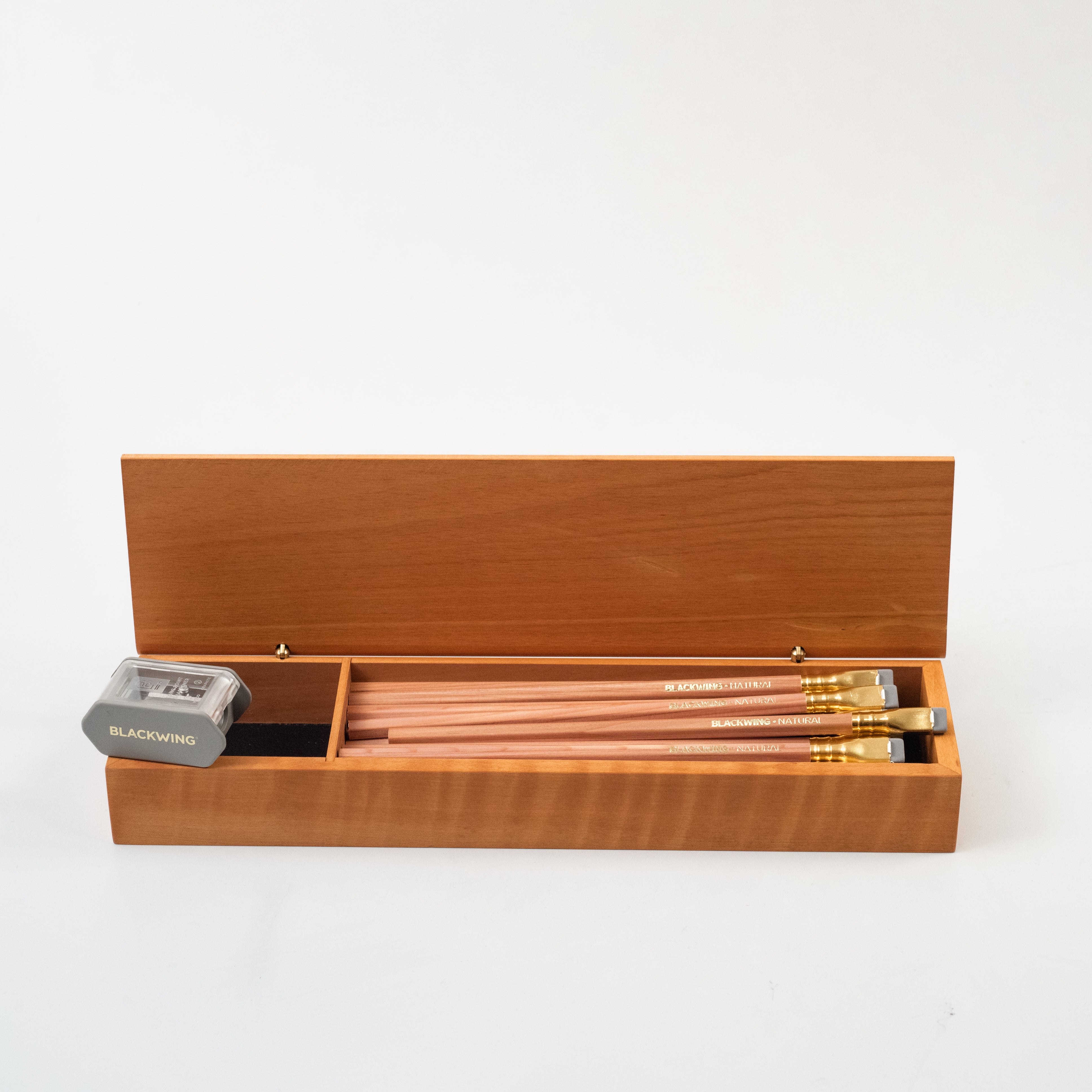 A Blackwing French Wood Box with Blackwing pencils and a pencil sharpener.