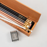 A Blackwing French Wood Box filled with Blackwing pencils and a pencil sharpener.