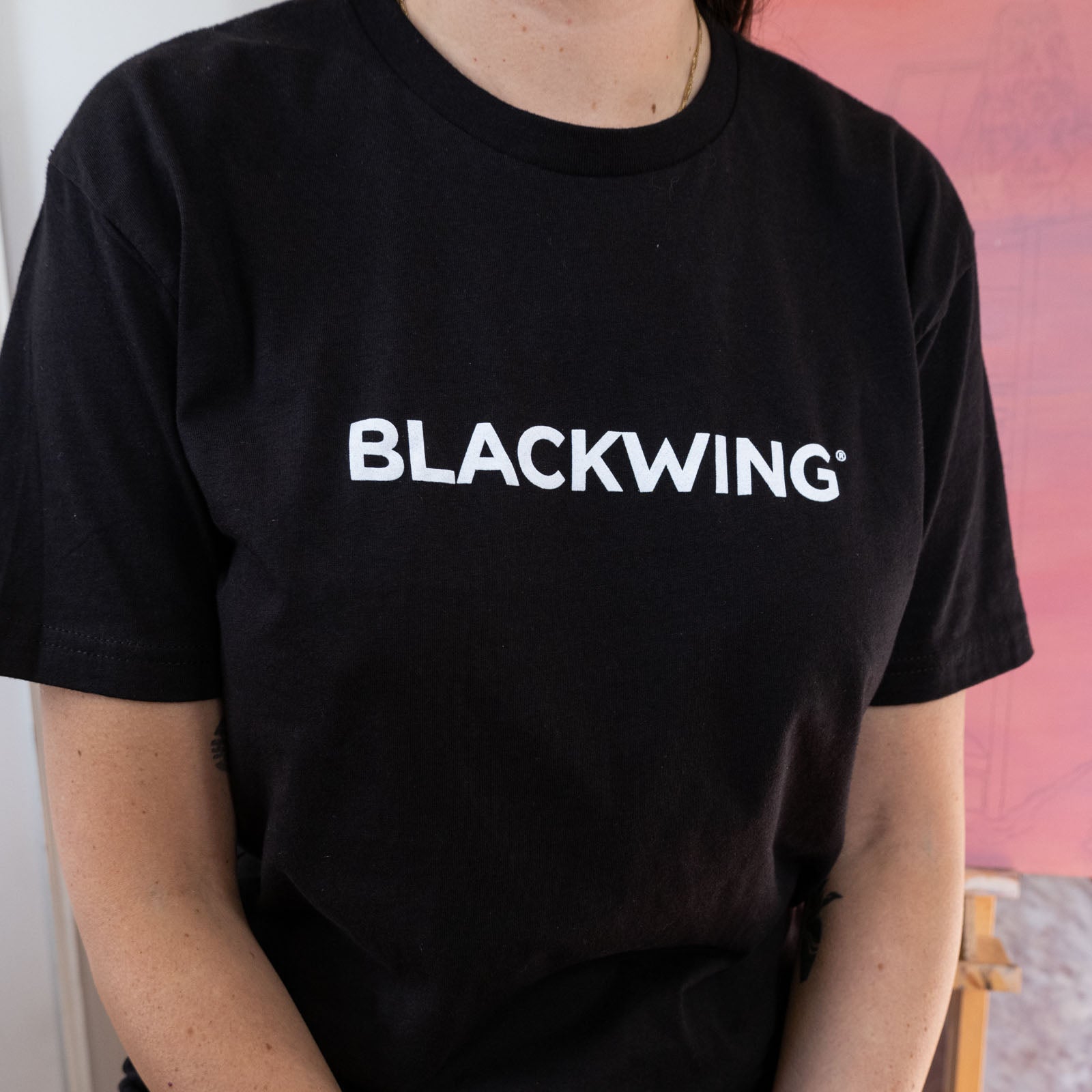 A woman wearing a Blackwing Logo Shirt from California.