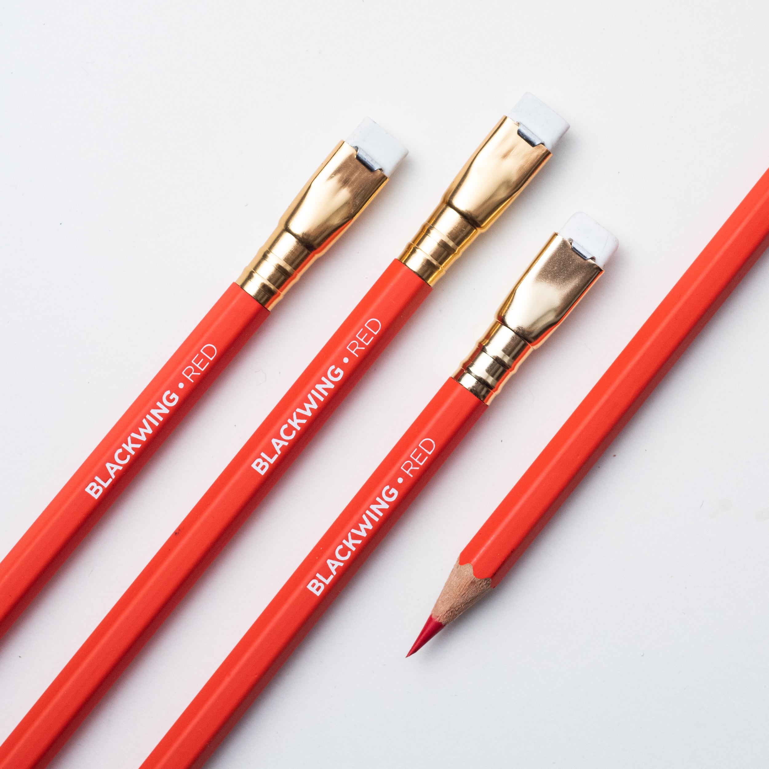 Three Blackwing Red pencils on a white surface, perfect for sketching.