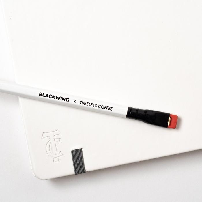 A White Blackwing x Timeless Coffee Slate Notebook with a Blackwing pen on top. A White Blackwing x Timeless Coffee Slate Notebook with a Blackwing pen on top.