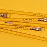 Three Blackwing Volume 3 (Set of 12) pencils are arranged on a bright yellow background.