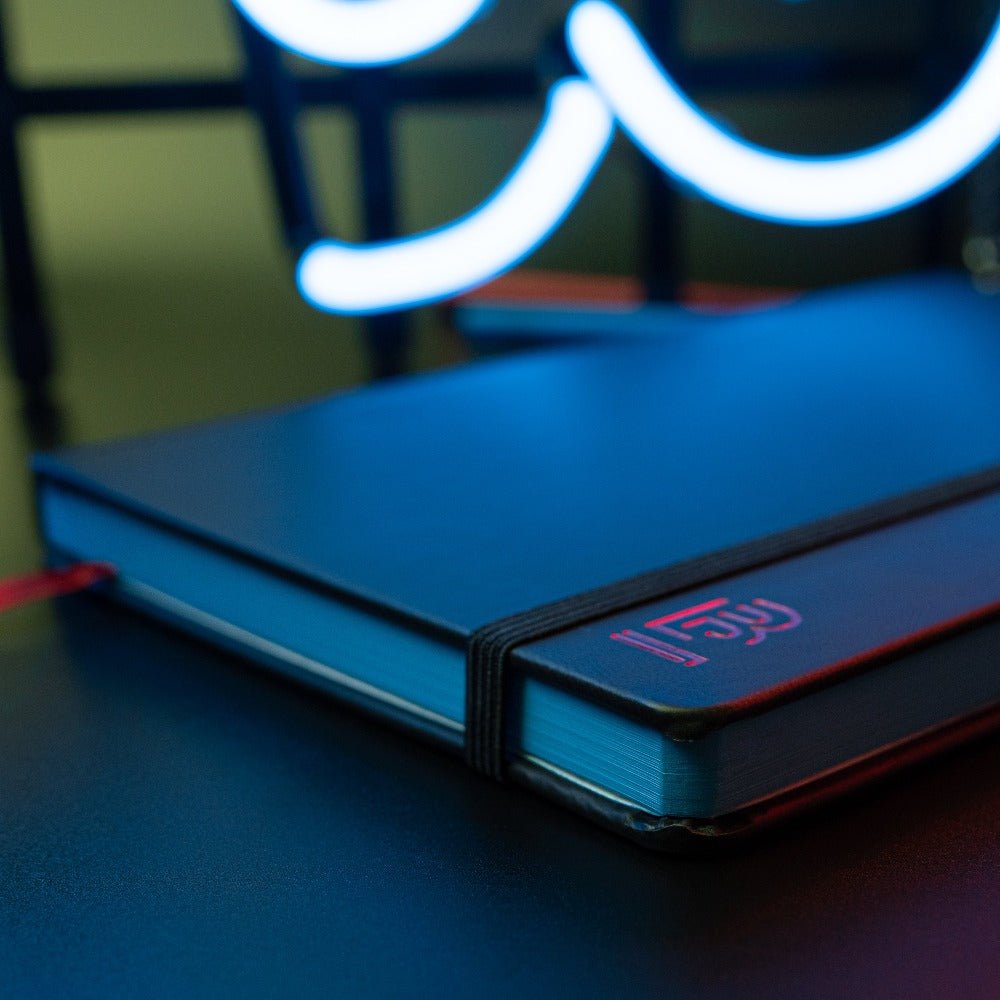 Blackwing Volume 6 Medium Slate Notebook in black with red "B" emblem and red placeholder ribbon Blackwing Volume 6 Medium Slate Notebook in black with red "B" emblem and red placeholder ribbon