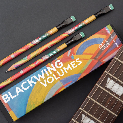 Blackwing Vol. 710 pencils beside a guitar neck