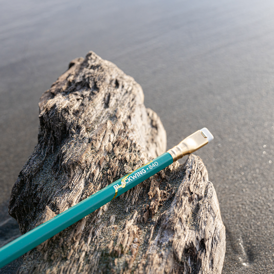 Blackwing Volume 840, the Surfing Pencil, sits atop a beach rock