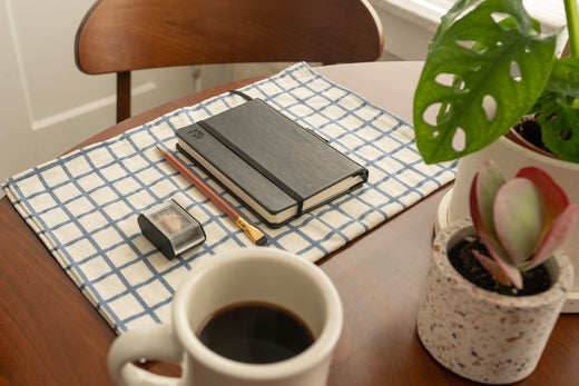 Blackwing Journaling Tips - a pencil, sharpener, journal, and mug with coffee sit on top of a desk