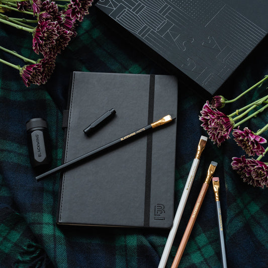 Blackwing notebook essentials set on a picnic blanket with flowers