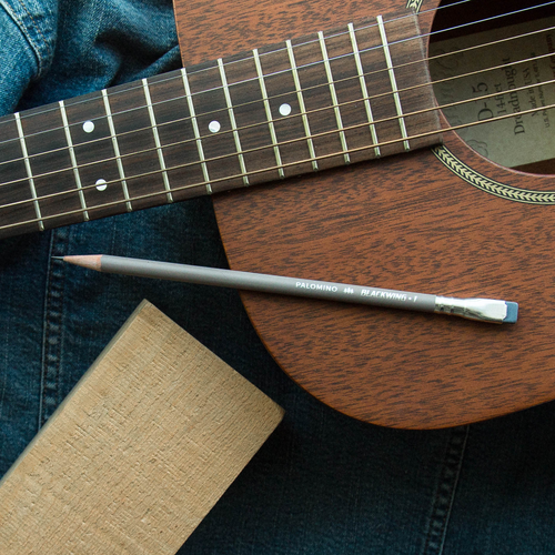 Blackwing Volume 1 grey pencil, a tribute to Guy Clark, sitting on top of a guitar