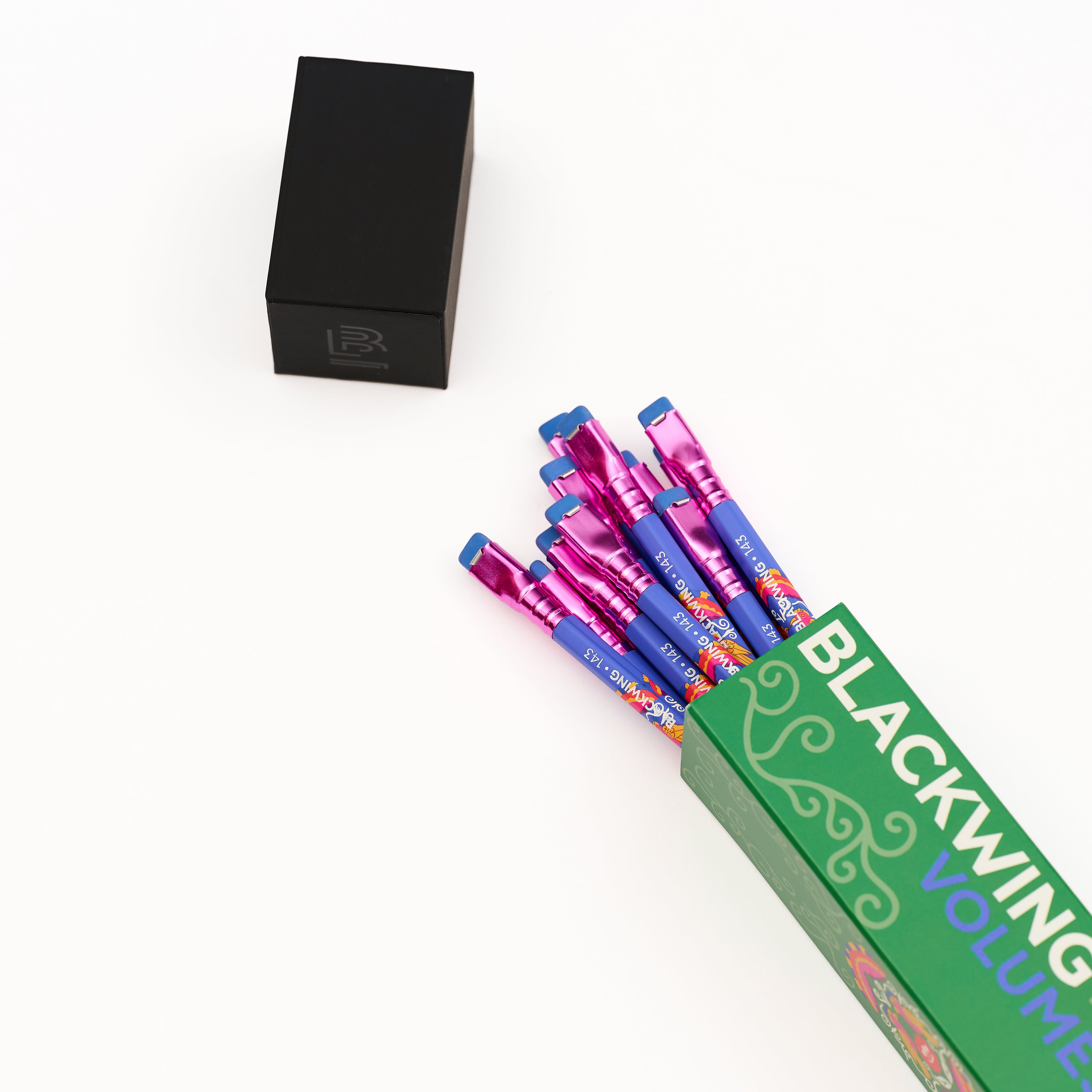 A set of colorful Blackwing Volume 143 pencils fanned out from a green box on a clean white background.