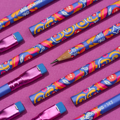 A set of colorful patterned pencils with pink ferrules and blue erasers arranged diagonally on a magenta background. One pencil is sharpened to show a wooden writing core.