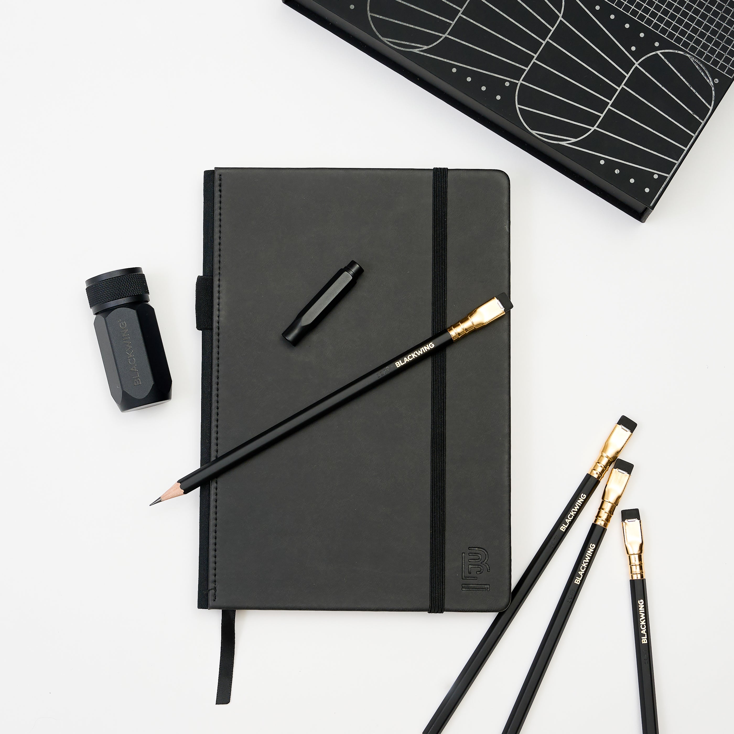 Stationery Set with black hardcover notebook, black pencils, black one-step sharpener, and black point guard