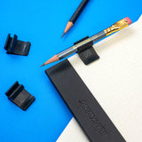 Blackwing Notebook Clip on notepad, holding a Blackwing 602 short