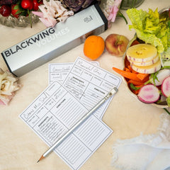 Blackwing Volume 140 pencil on top of recipe cards on a counter with fresh produce