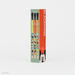 A boxed set of Disney Blackwing pencils standing upright on a clean white background. The packaging is mint green and bright orange-red, with printed character illustrations and the word BLACKWING prominently visible.