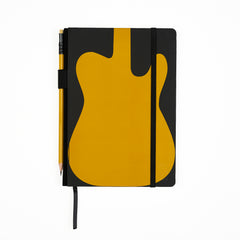 A black hardcover notebook with a large mustard yellow guitar-shaped graphic on the cover, shown closed with a black elastic closure. A yellow pencil is tucked into the side holster, and a black ribbon bookmark hangs from the bottom, on a clean white background.