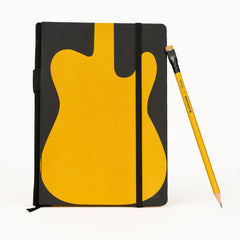 A black notebook with a large yellow guitar graphic on the cover, shown standing upright next to a yellow pencil on a clean white background.