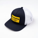 Blackwing trucker hat with yellow "Quality Pencils Made in Japan" embroided logo on front. Navy blue front, white mesh back. Adjustable snapback.