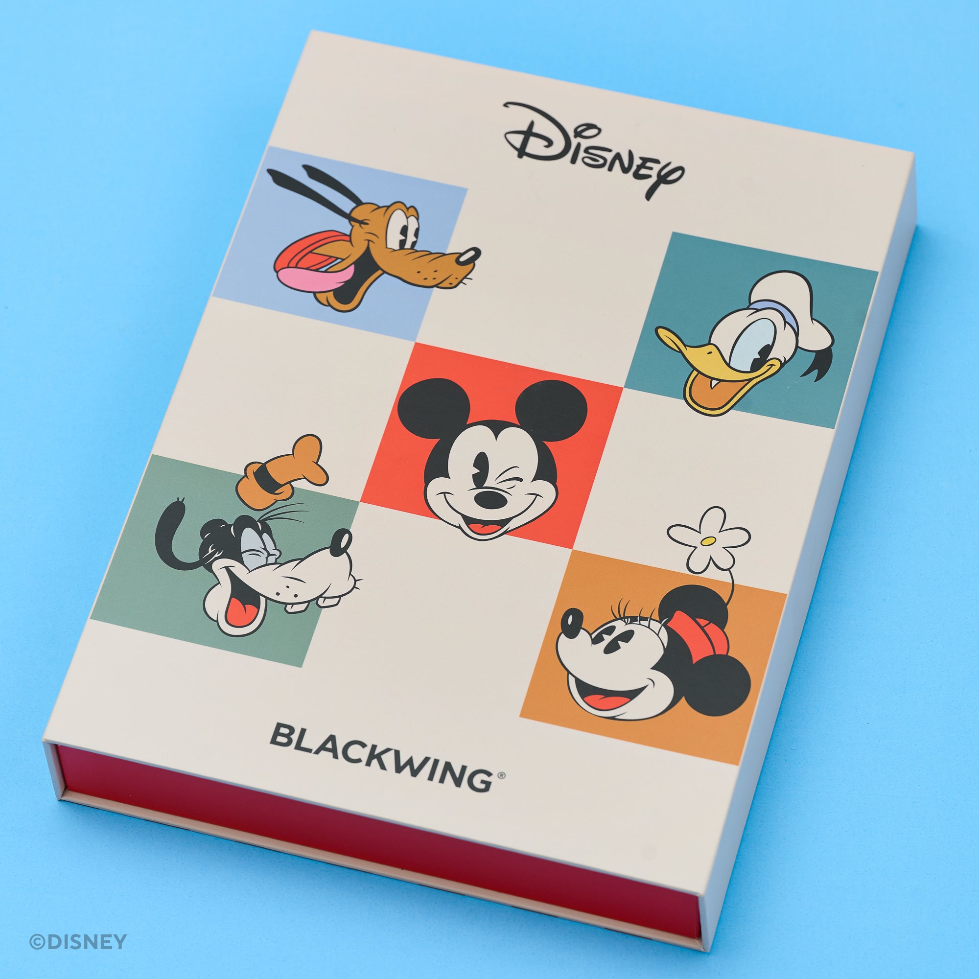 A Blackwing Disney-themed git set on a solid blue background. The cover features a cream-colored grid with colorful cartoon illustrations of Disney characters including Pluto, Donald Duck, Goofy, Mickey Mouse,  and Minnie Mouse, with the Disney logo at the top and BLACKWING at the bottom.