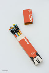 A set of Disney pencils by Blackwing in a matching red and white cardboard box, with the box lid placed above it on a clean white background.