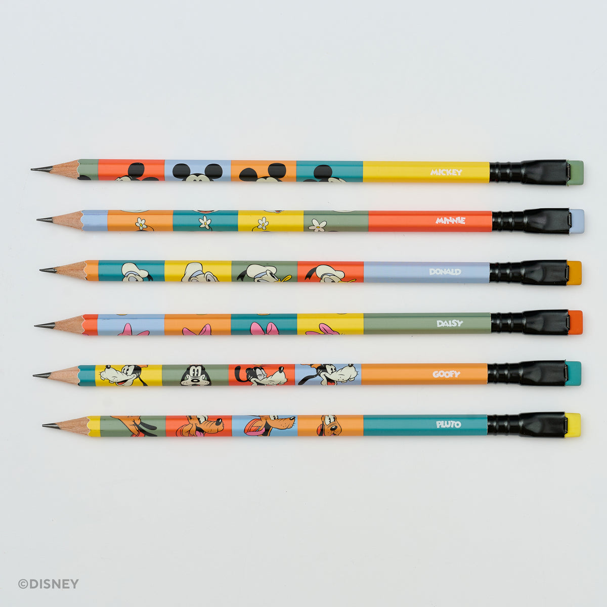 Six colorful Blackwing brand Disney-themed pencils arranged horizontally on a light gray background, featuring character illustrations and names including Mickey, Minnie, Donald, Daisy, Goofy, and Pluto. A small Disney watermark appears in the bottom-left corner.