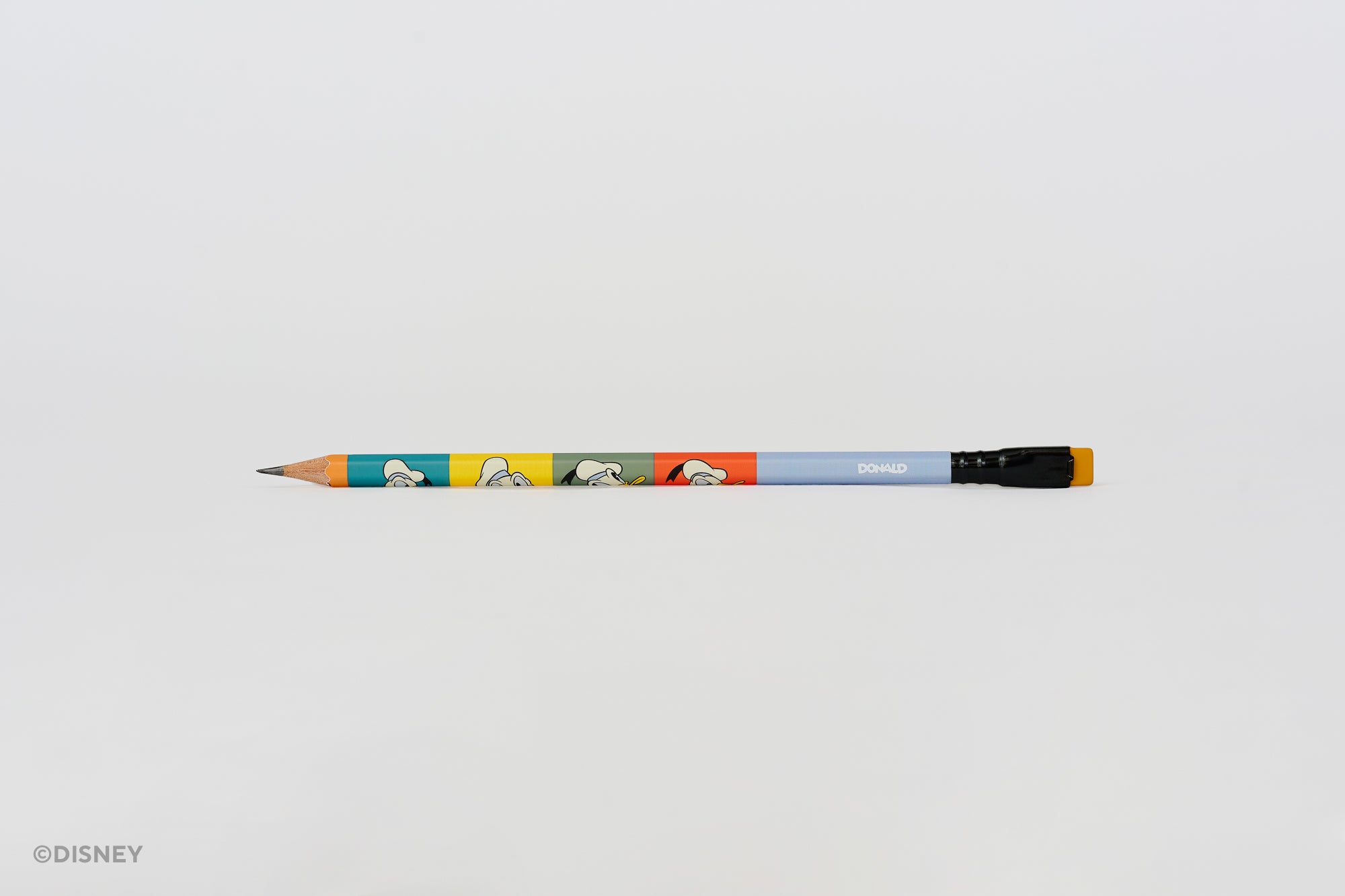 A Blackwing Disney pencil with a light blue barrel, featuring colorful Donald Duck illustrations, a black ferrule, and a mustard yellow eraser, shown horizontally against a plain white background.
