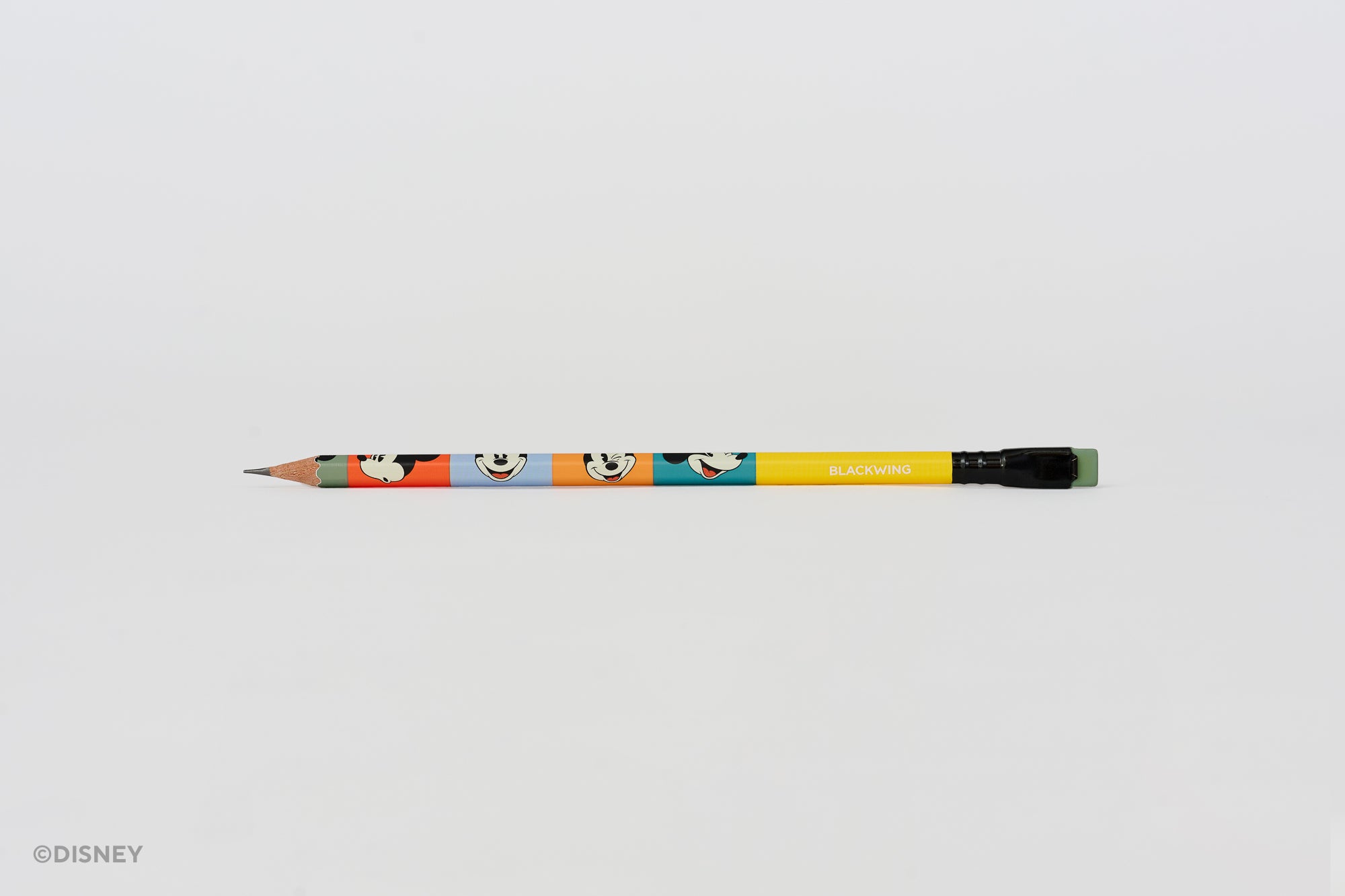 A yellow and multicolor pencil featuring Mickey Mouse face graphics and the text 'BLACKWING' on the barrel, photographed horizontally against a plain white background.