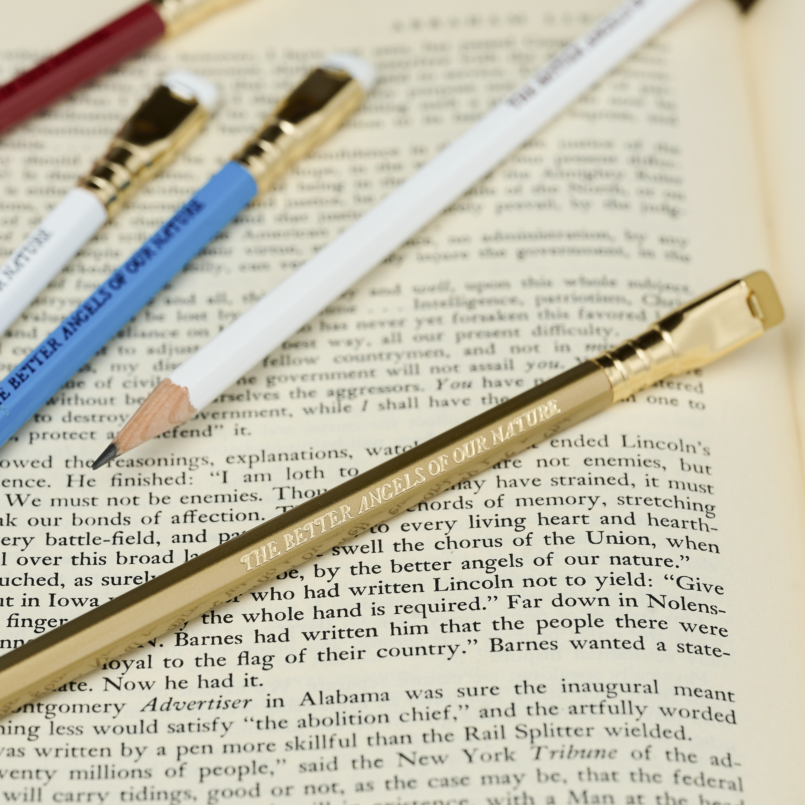 Blackwing pencils in red, white, blue, and gold, each with imprint 'THE BETTER ANGELS OF OUR NATURE' on top of an open book