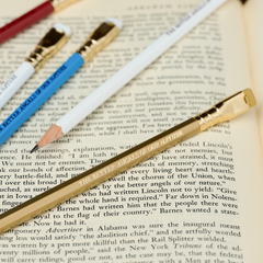 Blackwing pencils in red, white, blue, and gold, each with imprint 'THE BETTER ANGELS OF OUR NATURE' on top of an open book