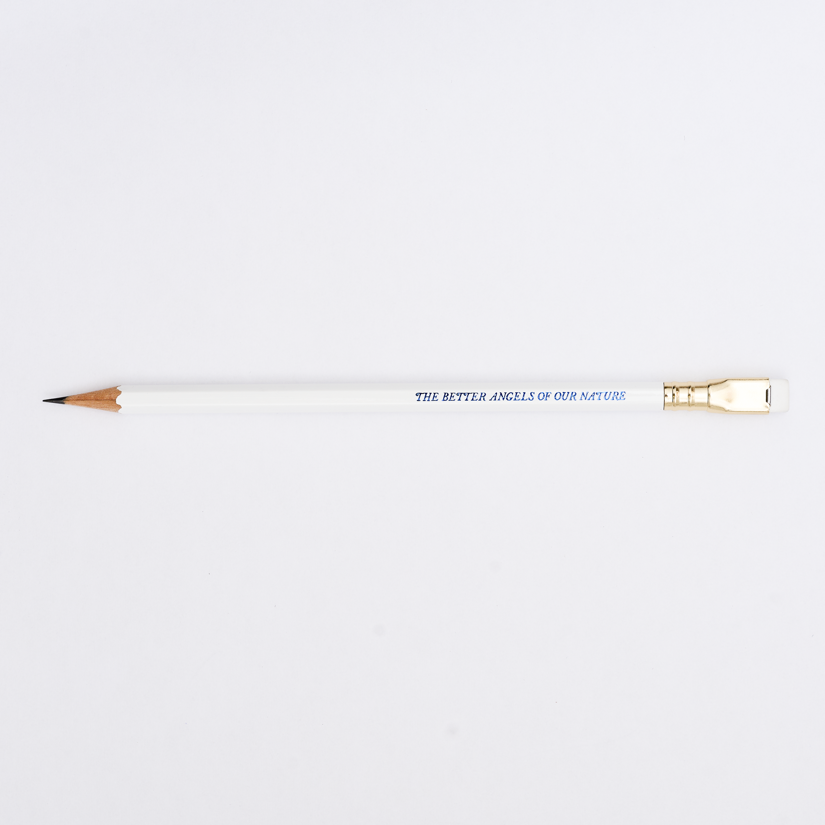 white pencil sharpened on a white background with pencil barrel text in blue that says 'THE BETTER ANGELS OF OUR NATURE'.